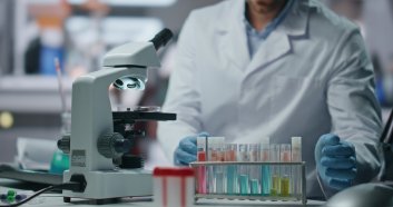 Biochemistry specialist making expertise drug samples in innovation laboratory close up. Serious man scientist working at vaccine from disease. Experienced lab researcher taking medicine test tubes.
