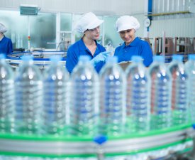 Drinking water factory worker at a production line of drinking water factory