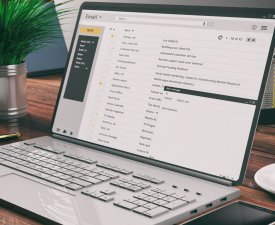 Emails on a computer laptop screen, wooden desk, office background. 3d illustration