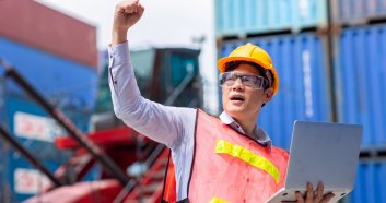 Happy Asian success professional male customs worker hand rising for in container port cargo shipping logistic industry.